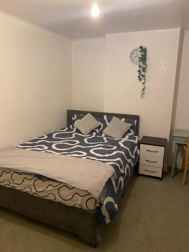 a bedroom with a bed with a black and white comforter at Incredibly spacious King size Room with full Main Floor of the Flat! in Oxford