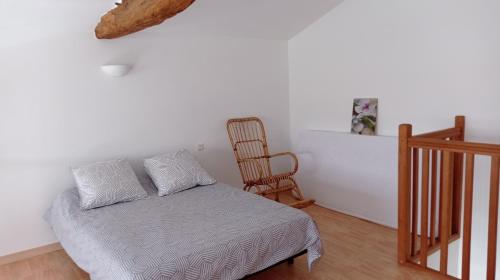 1 dormitorio con 1 cama y 1 silla en una habitación en Gîtes " la pagerie" en La Gaubretière