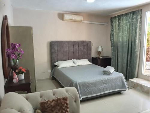 a bedroom with a bed and a couch at Villa rozenuda in Boca Chica
