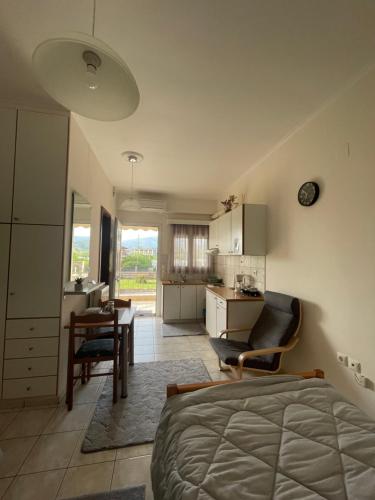 Cet appartement comprend une chambre avec un lit et une table ainsi qu'une cuisine. dans l'établissement Flo's Apartments, à Mesolongion