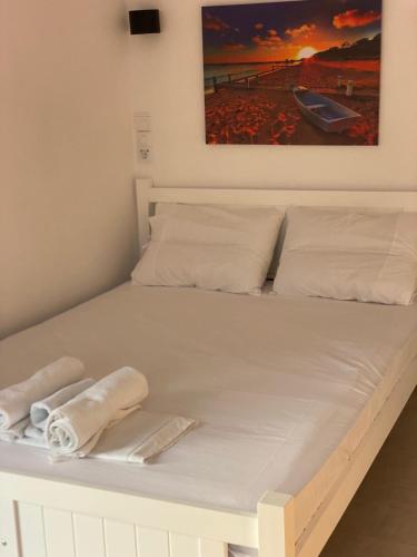 a white bed with two towels on it at Aggeliki Homes paradosiako nisiotiko in Poros