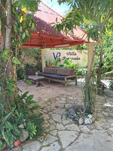 a pavilion with a bench in a garden at Villa rozenuda in Boca Chica