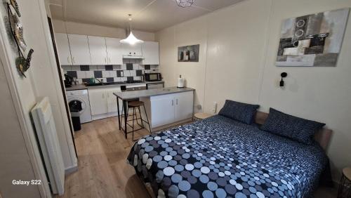 une petite chambre avec un lit et une cuisine dans l'établissement LE STUDIO REMCAM, à Saint-Mitre-les-Remparts