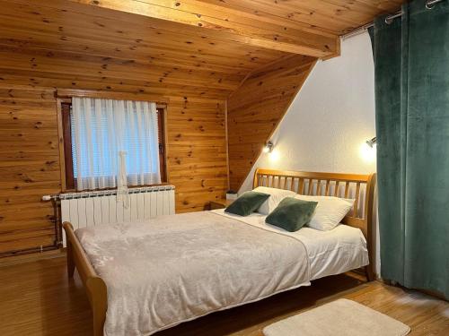 a bedroom with a bed in a wooden room at Guest house Zeder in Jezerce