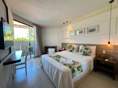 a hotel room with a bed and a television at Passagem Concept Hotel e Spa in Cabo Frio