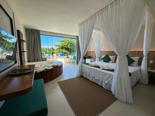 a hotel room with a bed and a tub and a bedroom at Passagem Concept Hotel e Spa in Cabo Frio