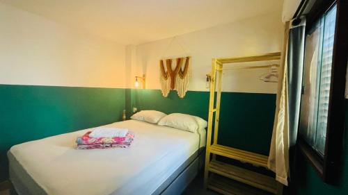 a small room with a bed and a mirror at Sunflower Hostel in Salvador