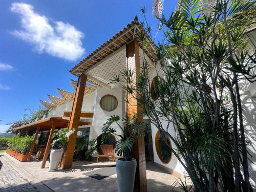 una casa blanca con plantas delante en Passagem Concept Hotel e Spa en Cabo Frío