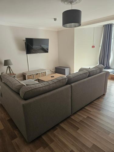 a large couch in a living room with a television at Close to amenities in Weston-super-Mare