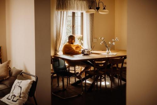 a man sitting at a table in a room at Odpoczywalnia Pakosław in Pakosław