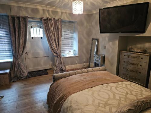 a bedroom with a bed with a television and a dresser at Close to amenities in Weston-super-Mare