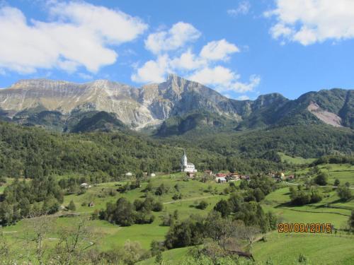 a village in a valley with mountains in the background at Rooms Pri Lovrižu in Kobarid