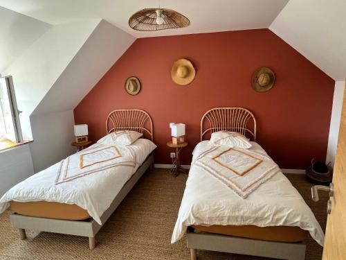 zwei Betten in einem Zimmer mit einer roten Wand in der Unterkunft Kelerdutbay fr, accès direct à la mer in Plouguerneau