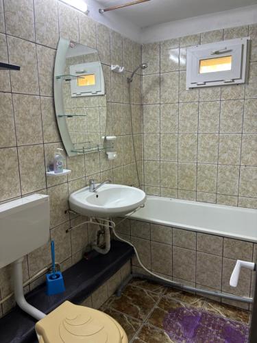 ein Badezimmer mit einem Waschbecken, einem WC und einer Badewanne in der Unterkunft Hypnotic Suite Pitesti in Piteşti