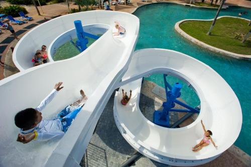 a group of children on a water slide at a water park at Holiday Inn Resort Grand Cayman by IHG in George Town