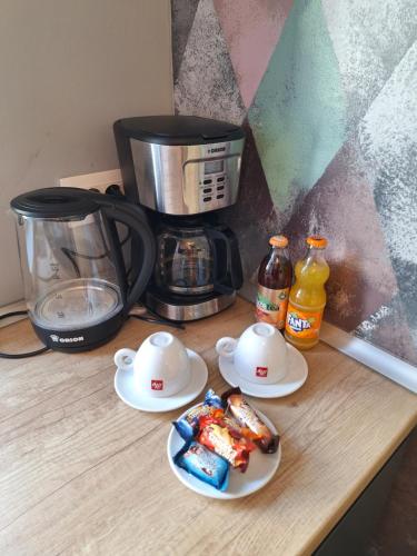 a counter with three plates of food and a coffee maker at Mirvana Apartments Legacy Residence in Timişoara
