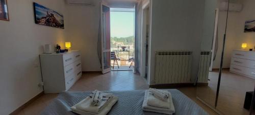 a bedroom with two towels on a bed and a window at Una finestra sul Golfo di Le Grazie in Le Grazie