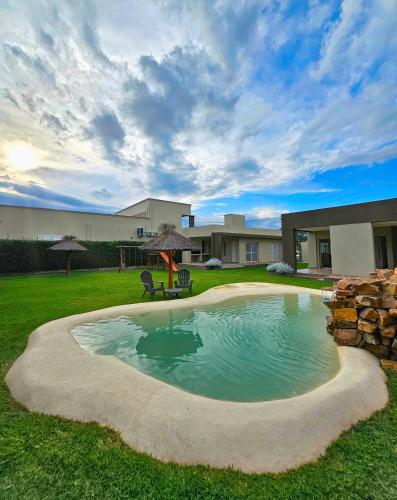 a swimming pool with an umbrella in a yard at Posadas Fratelli in Salta