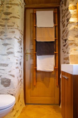 une salle de bain avec WC et une porte avec serviettes dans l'établissement ArcenFrance, à Sussac