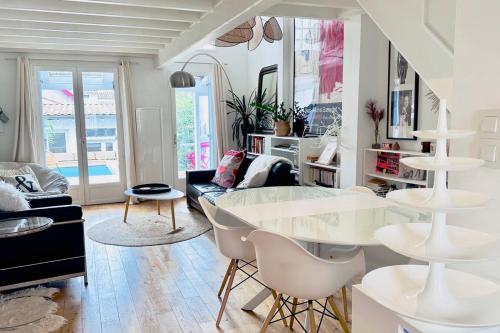 un salon blanc avec une table et des chaises dans l'établissement Magnificent house of 95 m with private pool, à Talence