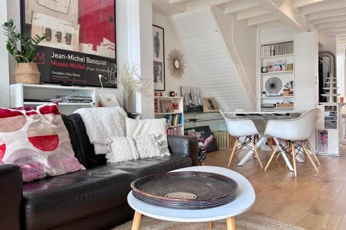 un salon avec un canapé noir et une table dans l'établissement Magnificent house of 95 m with private pool, à Talence