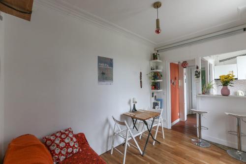 un soggiorno con divano e tavolo di Cozy two-room apartment in Montreuil a Montreuil