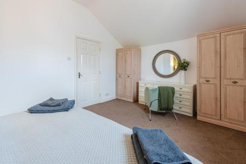 a bedroom with a bed and a dresser and a mirror at Brook Farm Barn in Frodsham