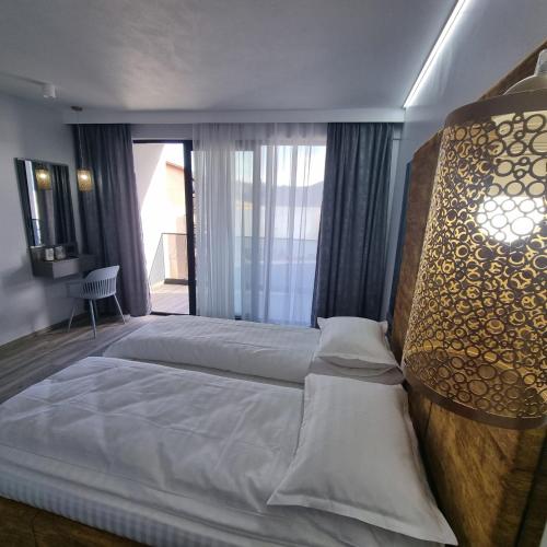 a bedroom with a large bed and a large window at Donau Resort in Eşelniţa