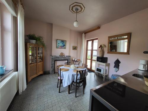 a dining room with a table and a fireplace at Charming and cosy ART DECO house in old historic farm with private natural pool and gardens with hiking and cycling trails nearby in Sint-Truiden
