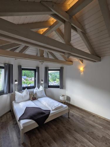 1 dormitorio con 1 cama blanca grande y ventanas en Ferienwohnung Mühl - einfach wohlfühlen, en Marienberg