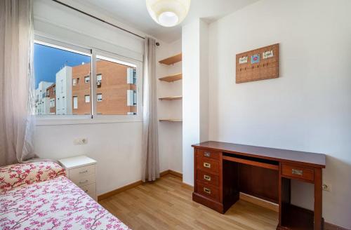 ein Schlafzimmer mit einem Bett, einem Schreibtisch und einem Fenster in der Unterkunft Sensacional piso en San Fernando in San Fernando