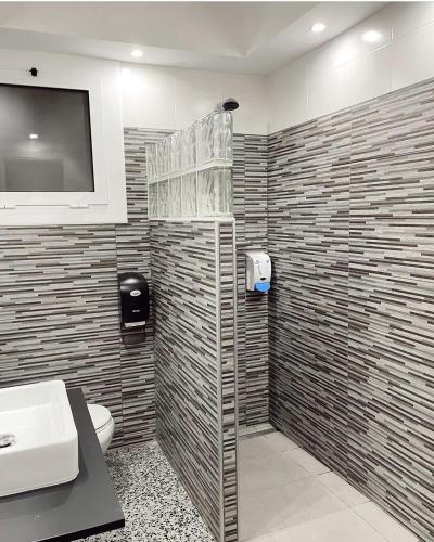 a bathroom with a toilet and a television on a wall at Hotel Gri-Mar in Llança