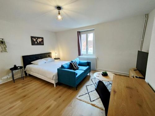 une chambre avec un lit et un canapé bleu dans l'établissement Paris VI - Séjour à Auxerre, à Auxerre