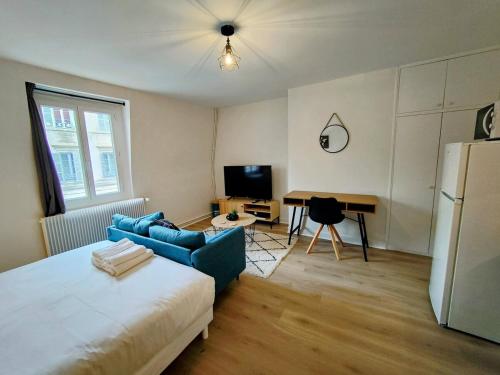 - un salon avec un canapé bleu et un réfrigérateur dans l'établissement Paris VI - Séjour à Auxerre, à Auxerre