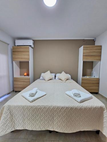 a bedroom with a large bed with two towels on it at Posadas Fratelli in Salta