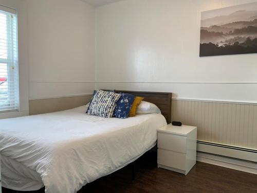 um quarto com uma cama com uma almofada e uma mesa de cabeceira em Large 1-bedroom Condo l Downtown l WiFi & Smart TV em Moose Jaw