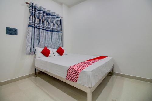 uma cama com almofadas vermelhas num quarto em OYO Flagship Hotel Roman Inn em Nagpur