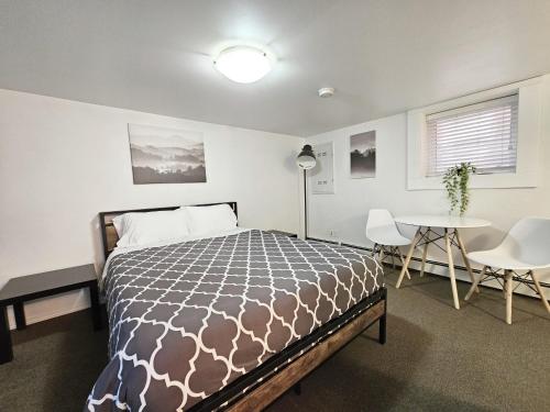 ein Schlafzimmer mit einem Bett und einem Tisch und Stühlen in der Unterkunft Modern 1BR at Downtown in Moose Jaw