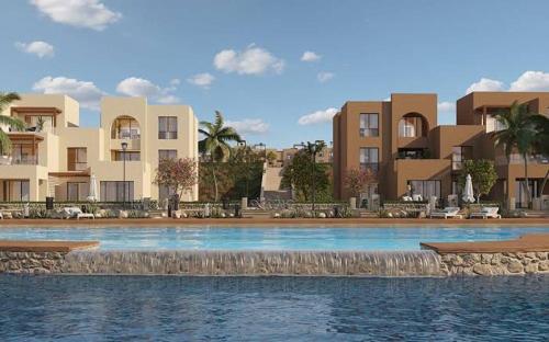 a swimming pool in front of some apartment buildings at Cozy Chalet in Makadi Heights in Hurghada