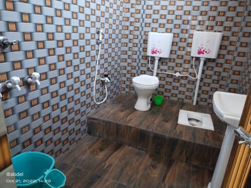 a bathroom with a toilet and a sink at Solomile Homestay in Farakka