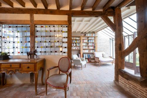 une chambre avec un bureau et des chaises dans une bibliothèque dans l'établissement Le Clos Souvigny Centre ,15 min Parc Fédéral Lamotte CAUTION OBLIGATOIRE SWIKLY, à Souvigny-en-Sologne