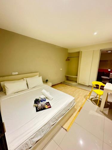 a bedroom with a large white bed and a yellow chair at Swing & Pillows - Kajang Selangor in Kajang