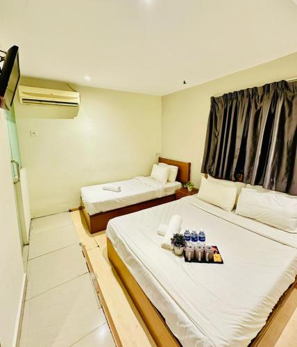 a hotel room with two beds and a window at Swing & Pillows - Kajang Selangor in Kajang