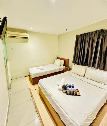 a hotel room with two beds and a window at Swing & Pillows - Kajang in Kajang