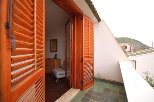 een open deur naar een kamer met een stoel en een tafel bij Casa Sciusca in Cefalù