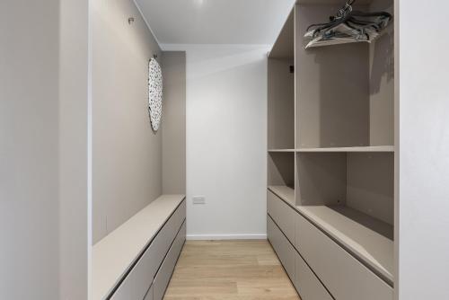 a walk in closet with white walls and gray cabinets at Modern 1BR Flat in the Heart of Milton Keynes in Milton Keynes