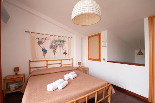 een slaapkamer met een bed met opgerolde handdoeken bij Casa Sciusca in Cefalù
