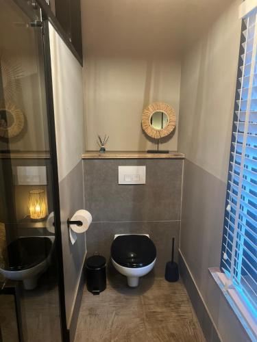 a bathroom with a black toilet and a sink at Casa Fuori in Oirschot