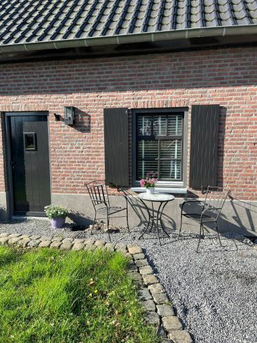 a patio with chairs and a table in front of a building at Casa Fuori in Oirschot