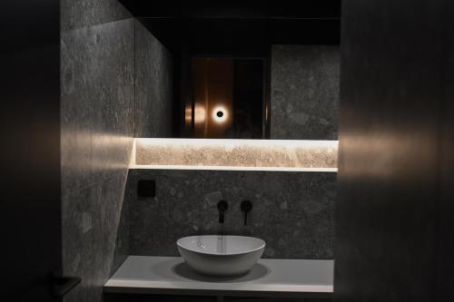 a bathroom with a bowl on a counter with a mirror at Căsuța din livadă in Măneciu